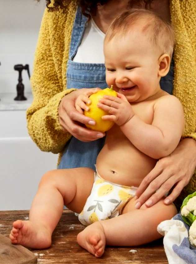 baby on the counter touching fruits