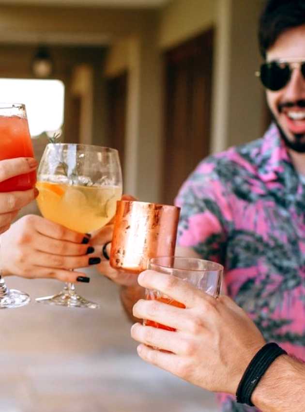 women and men in summer with a cocktail in their hands