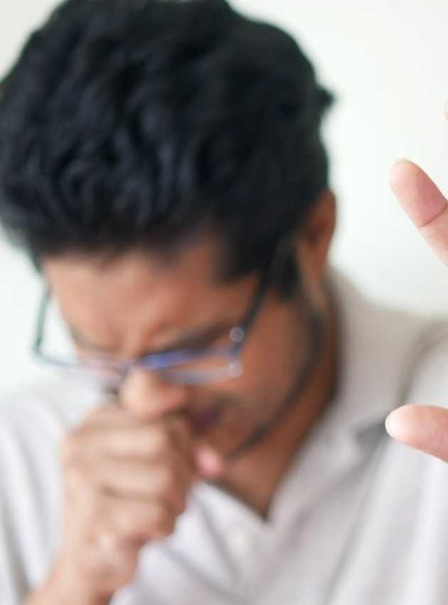 man in white sweater putting his hand in front of him