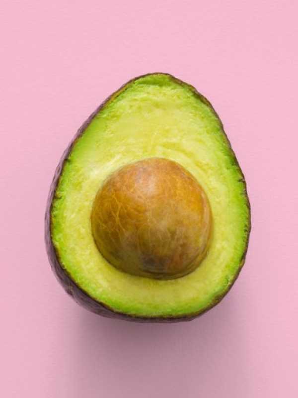 avocado in front of a pink background