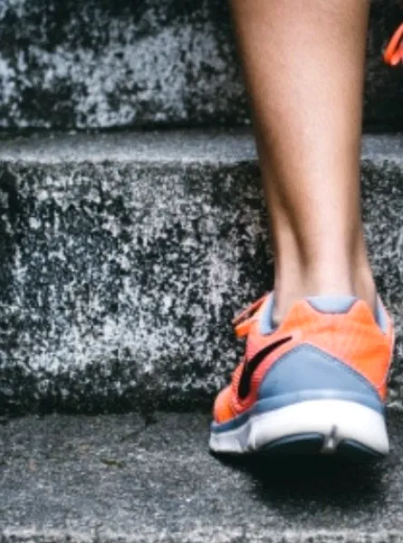 a person climbing the stairs in sports shoes