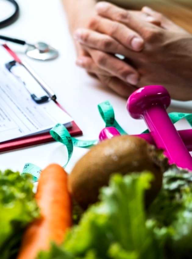 Toronto Dietitian Nutritionnist near you holding an apple and taking notes while talking to her client