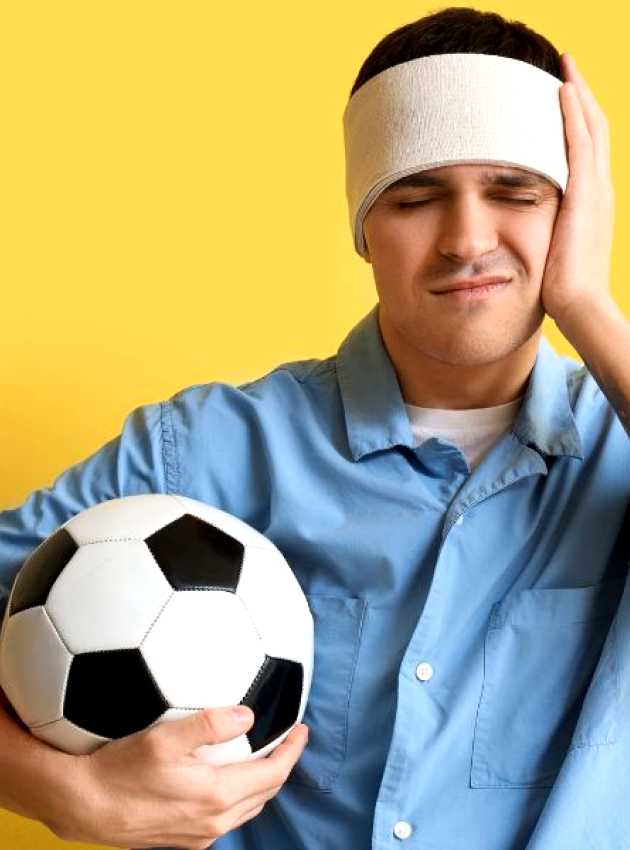 a person with a bandage on their head holding a soccer ball