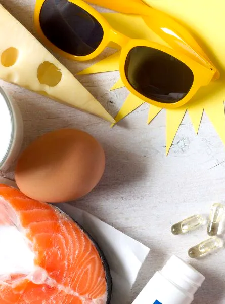 Ingredients arranged on a light surface: salmon, eggs, cheese, a glass of milk, a small bottle, and a comic-style yellow burst with sunglasses.
