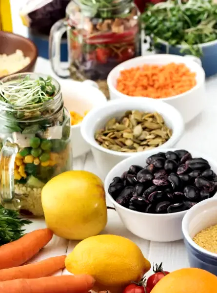A person is holding a bowl of vegetables and other healthy ingredients for cholesterol management