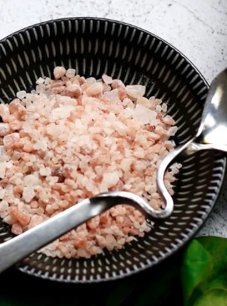 bowl of Himalayan salt with spinach on the side