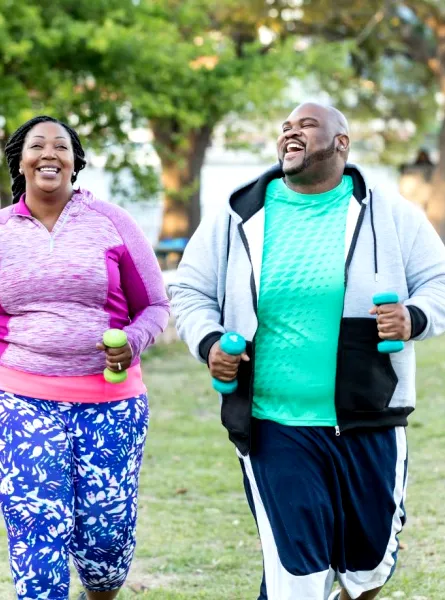 A smiling plus size couple jogs outdoors - Un couple en surpoids souriant fait du jogging en extérieur