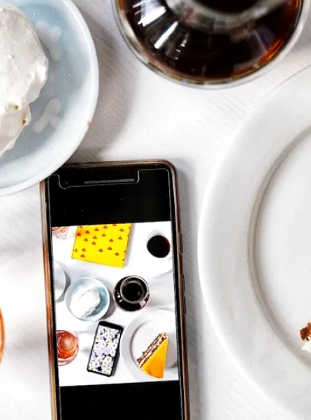 A cellphone  surrounded by food and drinks