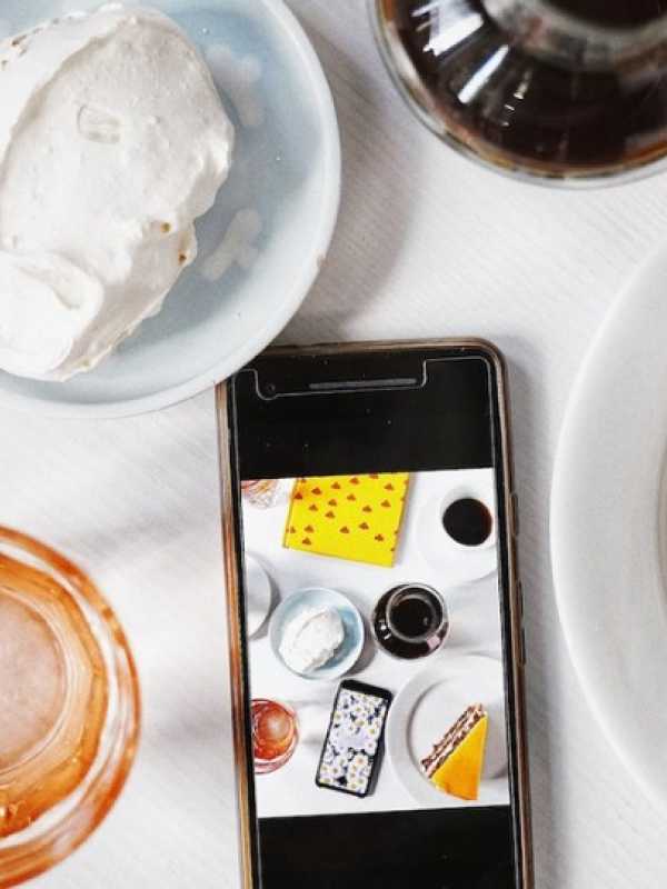 A cellphone  surrounded by food and drinks