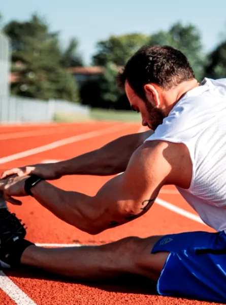 A person stretching on a racetrack