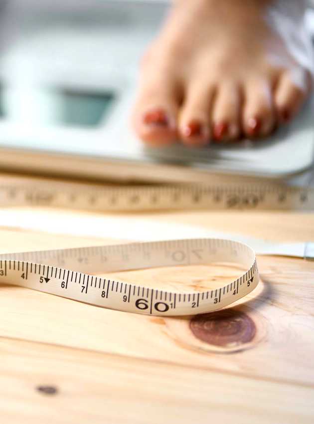 Pieds sur une balance avec ruban à mesurer - Feet on scale with measuring tape