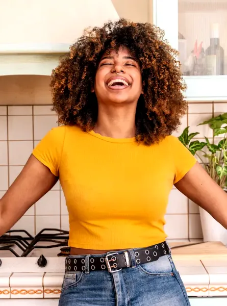 Femme souriante appuyée sur le comptoir de sa cuisine - Smiling woman leaning on her kitchen counter with grocery bags