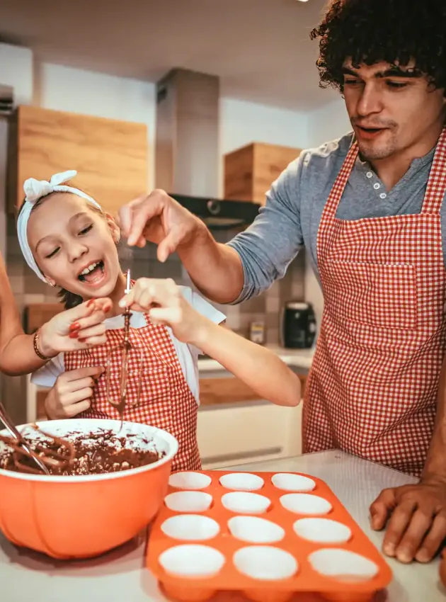 Famille souriante en train de cuisiner un dessert - Smiling family cooking a dessert together