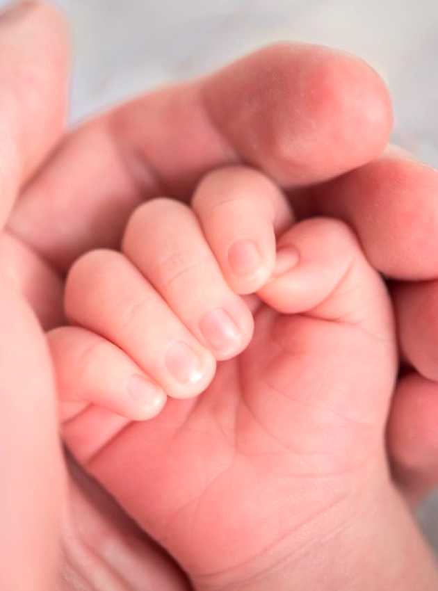 Hand of a baby in the hand of her mother