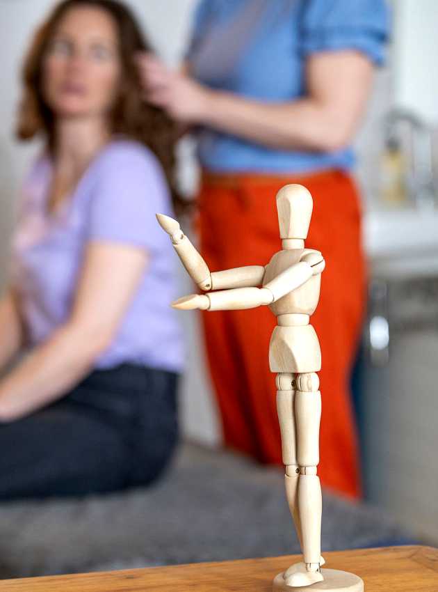 A wooden mannequin in focus on a table - Un mannequin en bois net sur une table