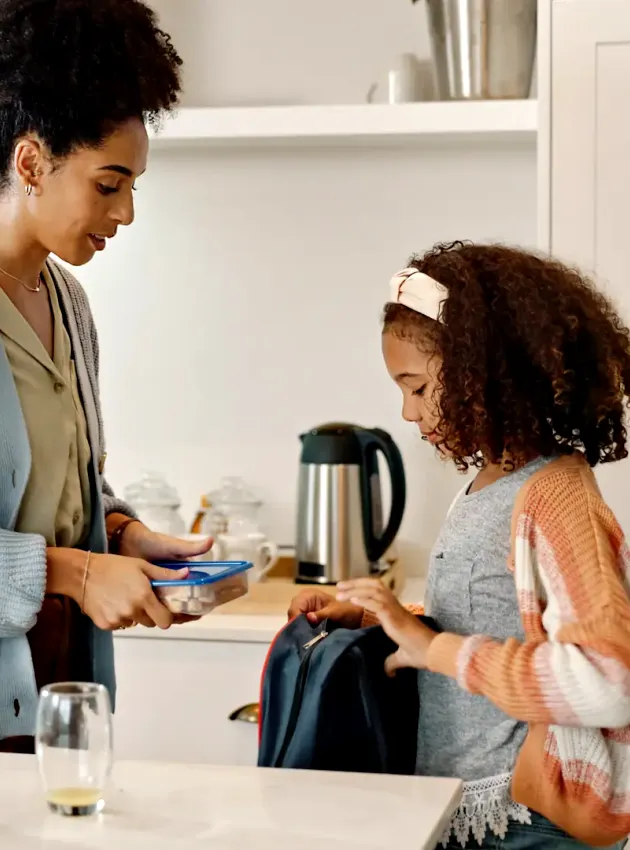 Maman préparant une boîte à lunch pour sa fille - Mom packing a lunchbox for her daughter