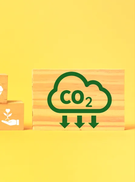 stacked wooden blocks with ecological shapes painted white on a yellow background