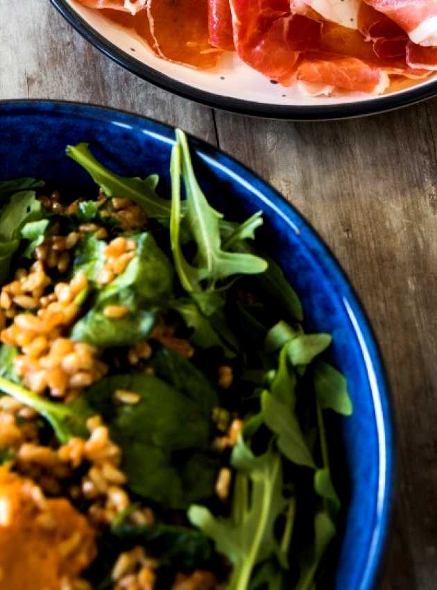 Arugula salad with prosciutto on a table