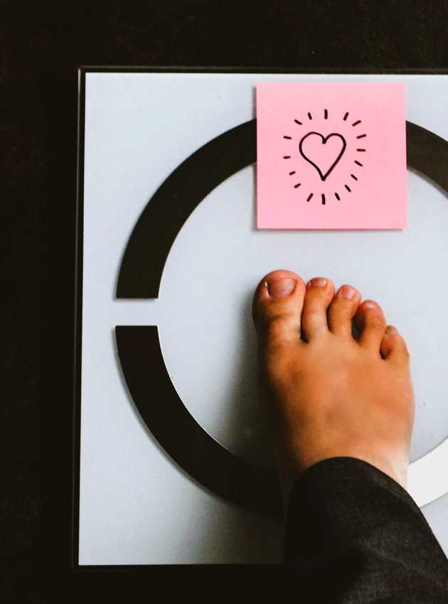 Pied sur une balance avec post it coeur - Foot on scale with a heart post it