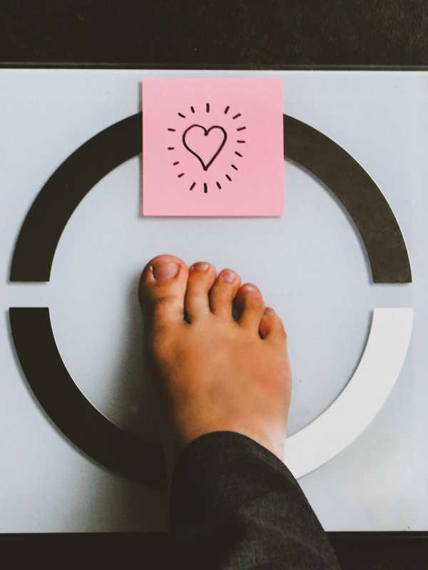 Pied sur une balance avec post it coeur - Foot on scale with a heart post it