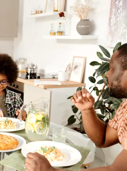 Famille souriante partageant un repas - Smiling family sharing a pasta meal